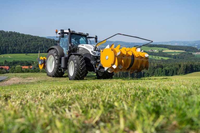Front-mounted silage spreader on Steyr tractor in combination with silage roller