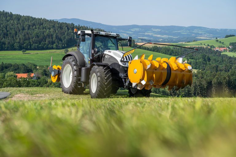 Siloverteiler schwenkbar auf Steyr Traktor mit Silowalze im Heck